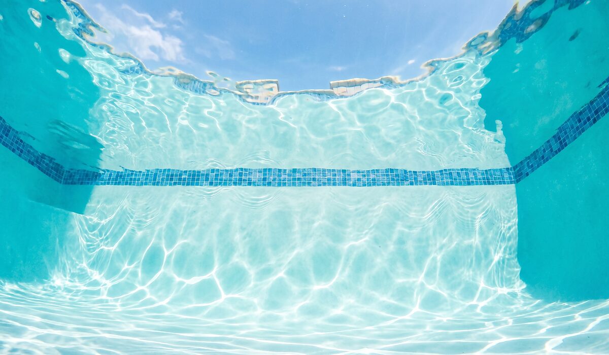 Underwater view of a clear swimming pool with sunlight through the water