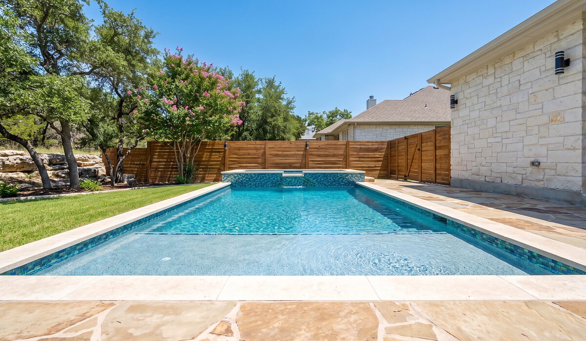 Remodeled swimming pool with new tile and coping on a sunny day