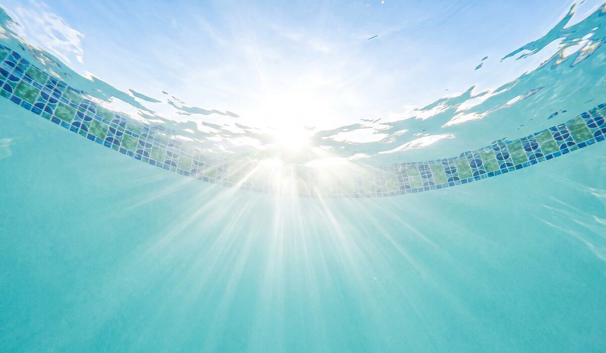 Underwater view of a clear swimming pool with sunlight through the water