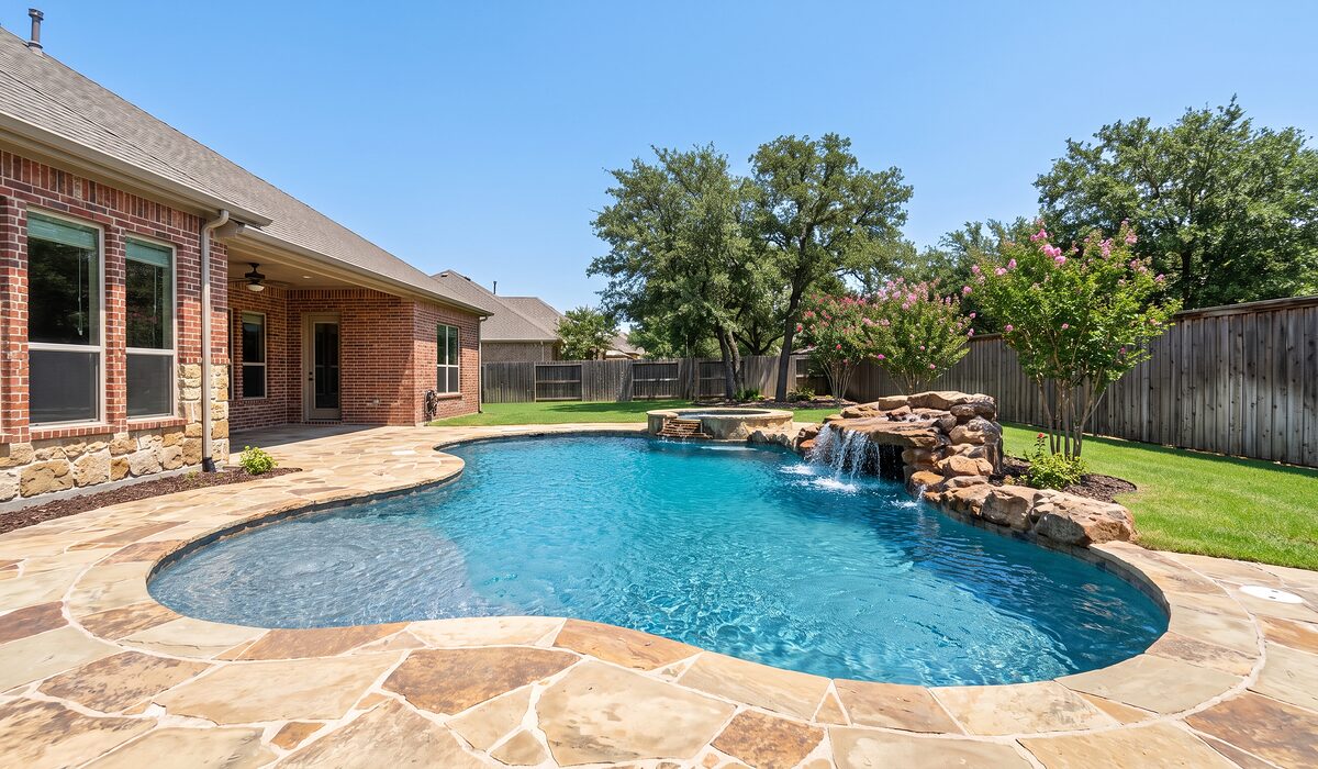 Newly built custom gunite pool with a travertine deck at a Texas home
