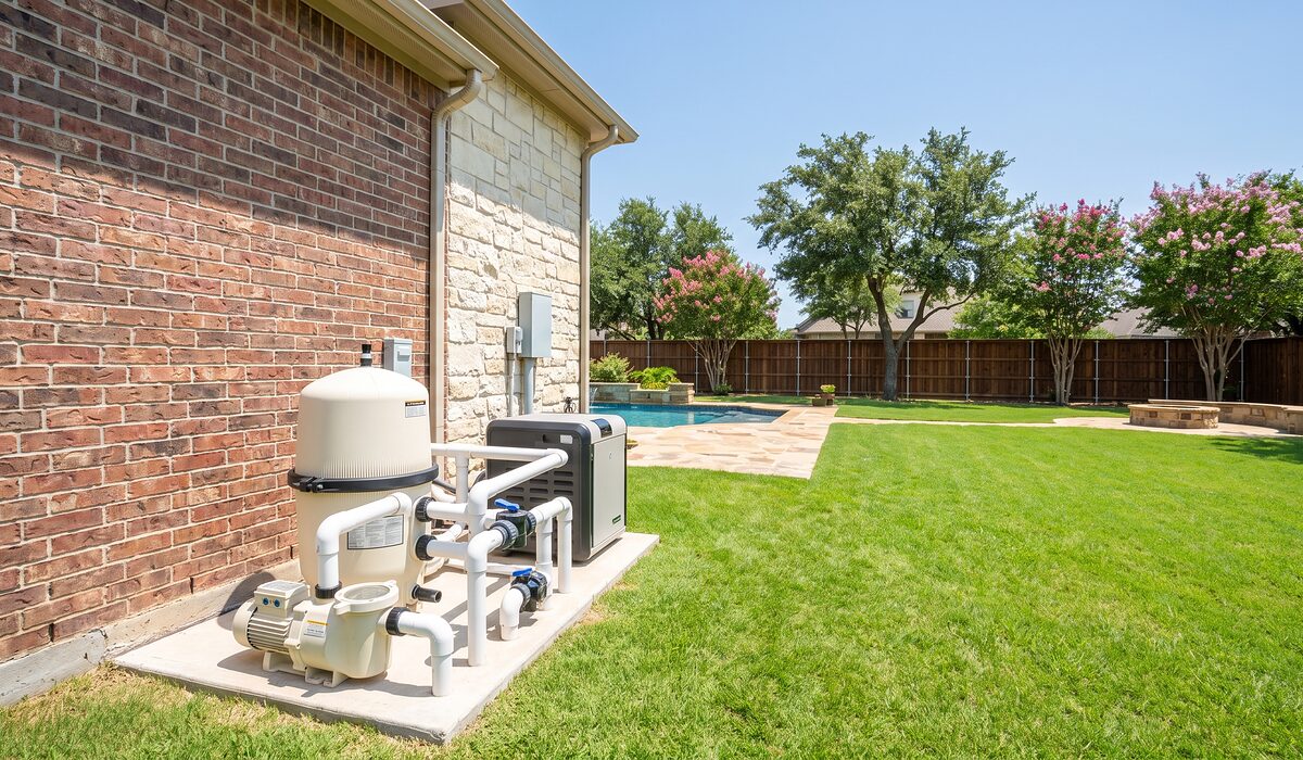 Pool equipment pad with pump, filter, and plumbing beside a Texas home