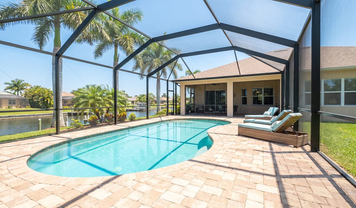 Sparkling backyard swimming pool inside a screened lanai at a Florida home