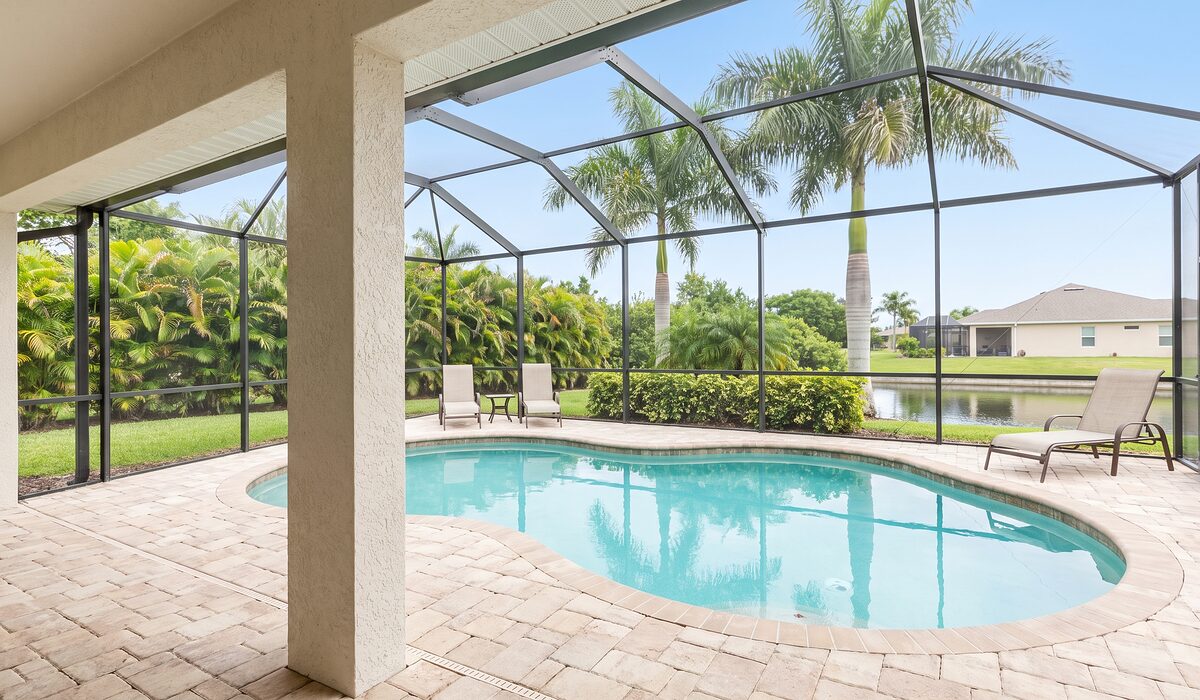Sparkling backyard swimming pool inside a screened lanai at a Florida home