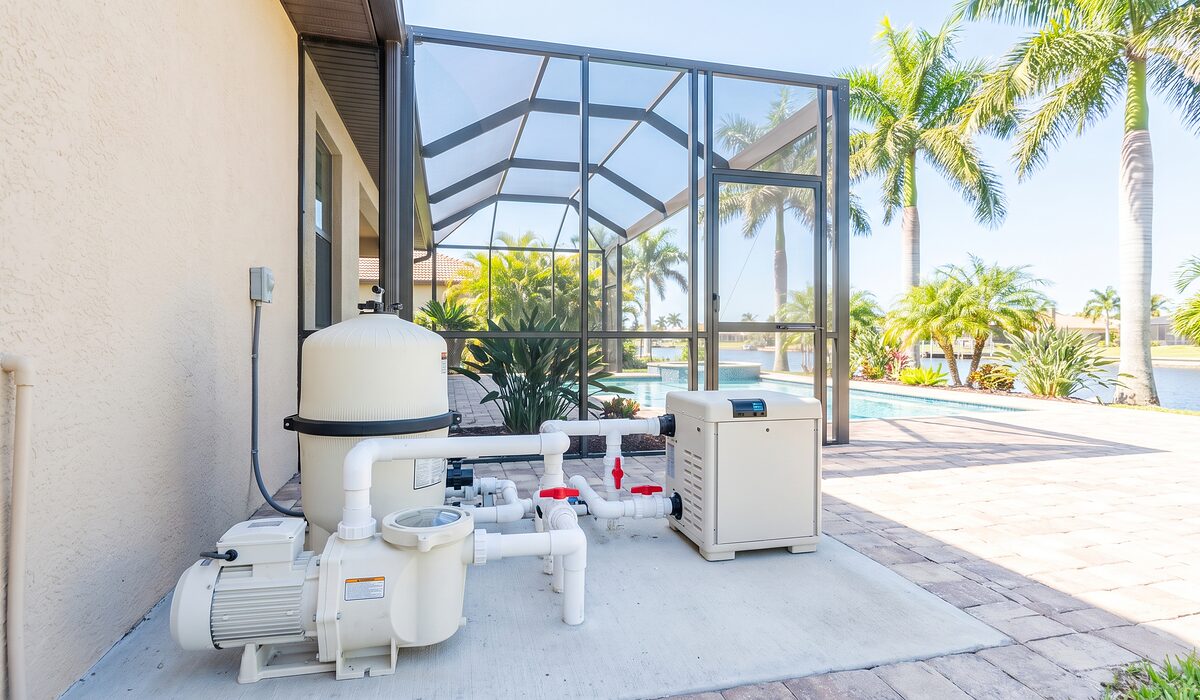 Pool equipment pad with pump, filter, and plumbing beside a Florida home