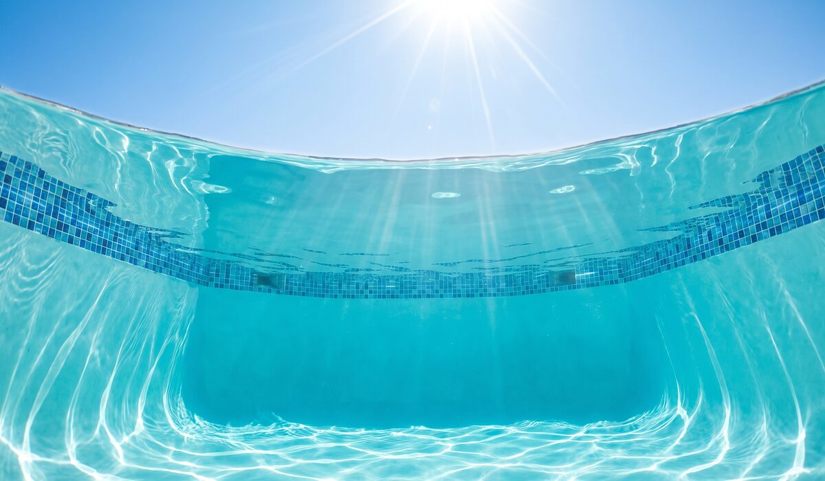 Underwater view of a clear swimming pool with sunlight through the water
