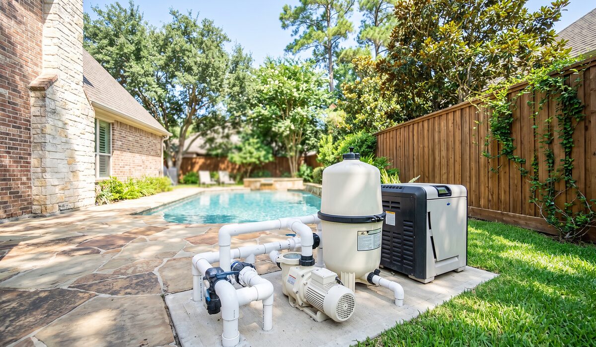 Pool equipment pad with pump, filter, and plumbing beside a Texas home