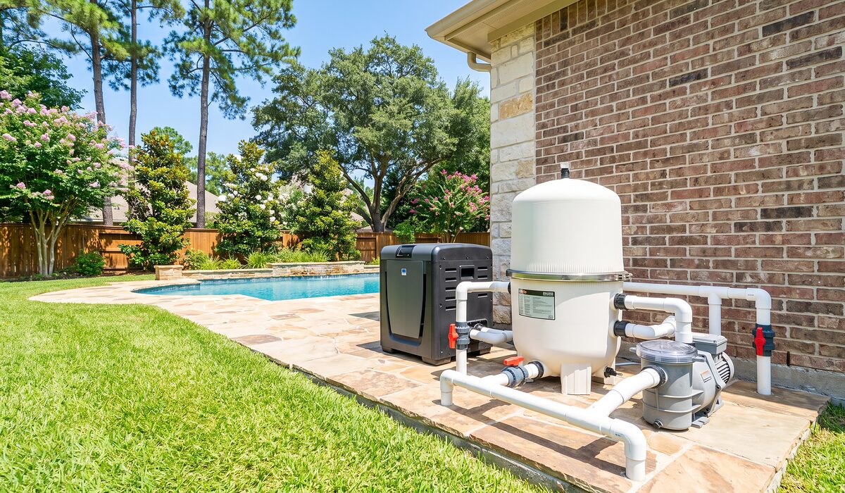 Pool equipment pad with pump, filter, and plumbing beside a Texas home
