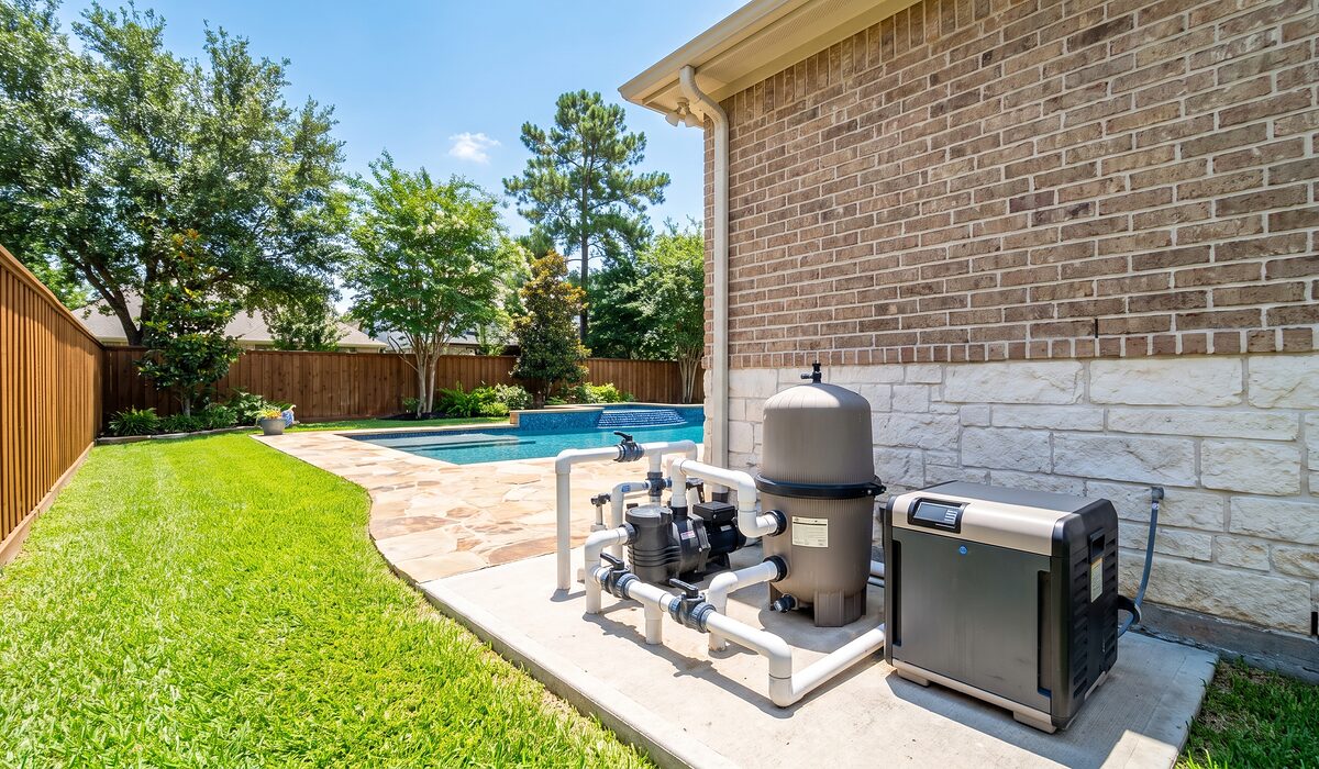 Pool equipment pad with pump, filter, and plumbing beside a Texas home