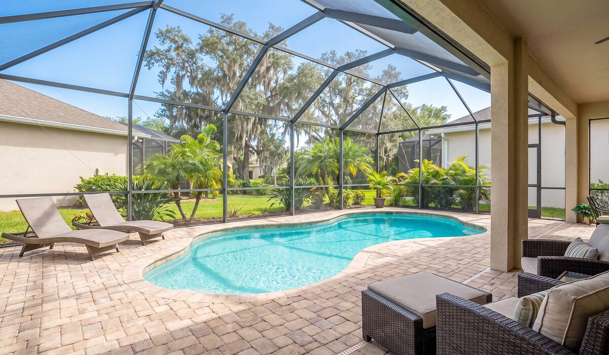 Sparkling backyard swimming pool inside a screened lanai at a Florida home