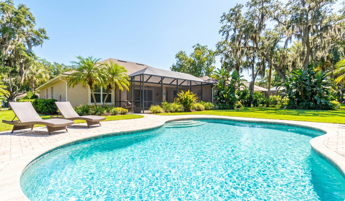 Sparkling backyard swimming pool inside a screened lanai at a Florida home
