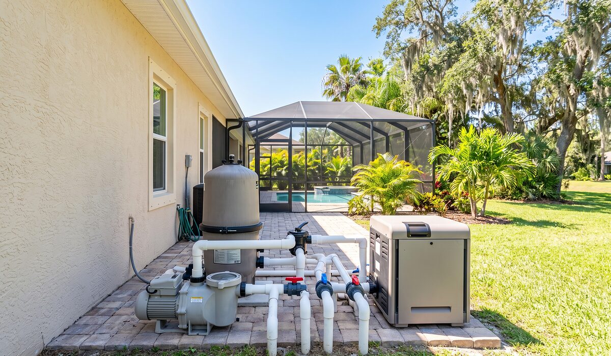 Pool equipment pad with pump, filter, and plumbing beside a Florida home