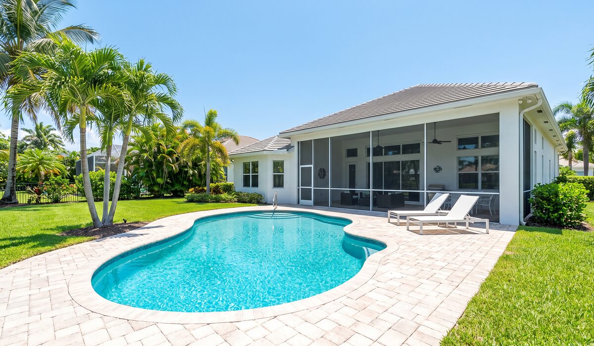 Sparkling backyard swimming pool inside a screened lanai at a Florida home