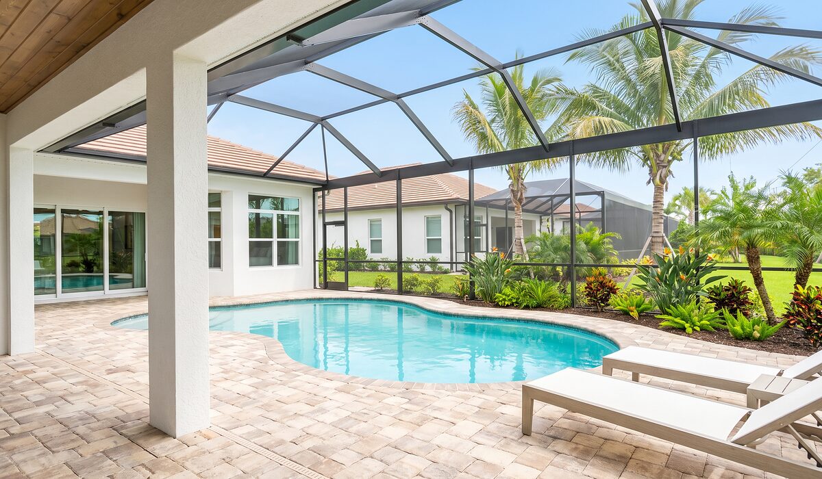 Sparkling backyard swimming pool inside a screened lanai at a Florida home