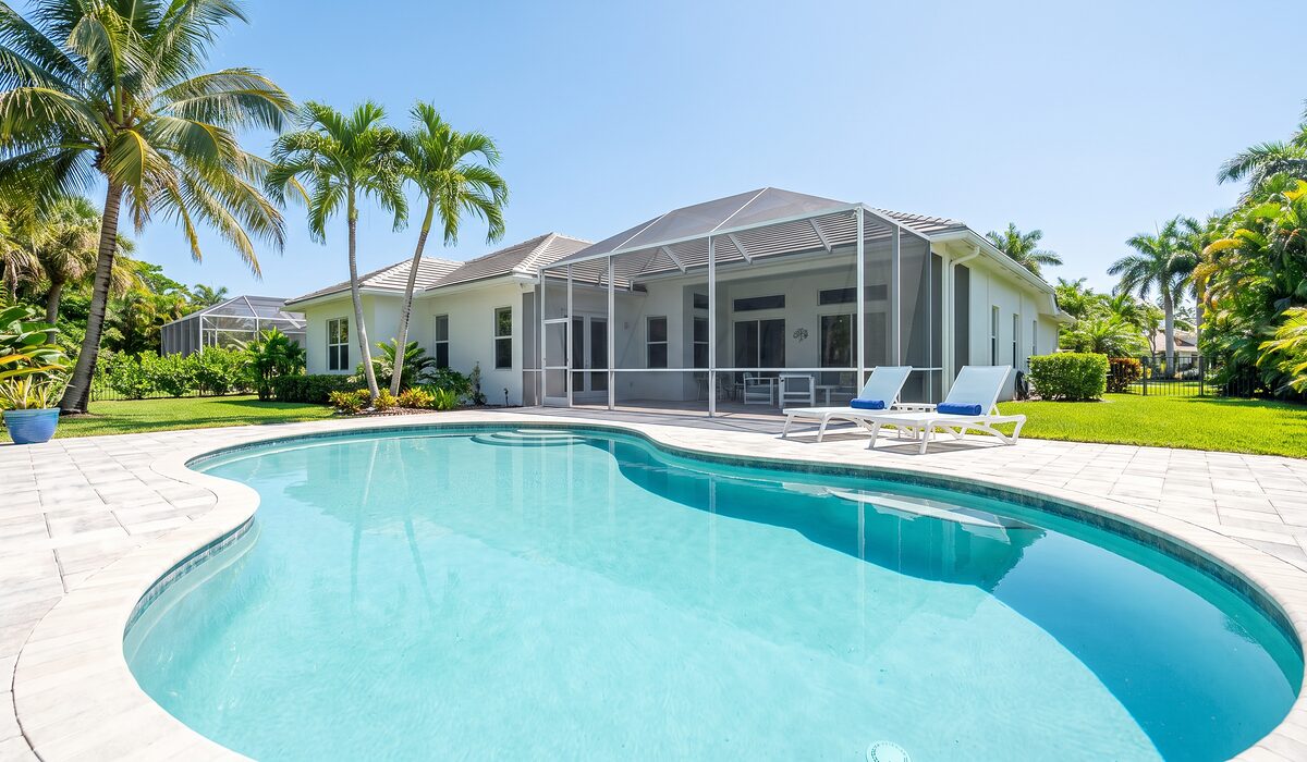 Sparkling backyard swimming pool inside a screened lanai at a Florida home