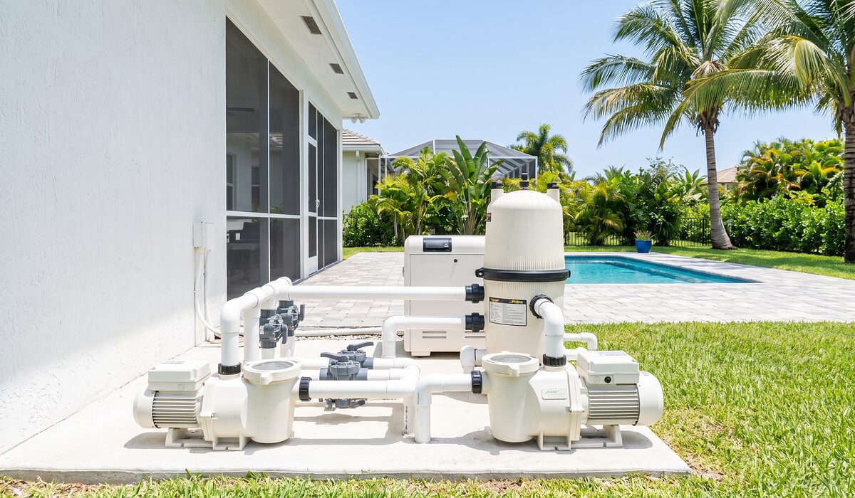 Pool equipment pad with pump, filter, and plumbing beside a Florida home