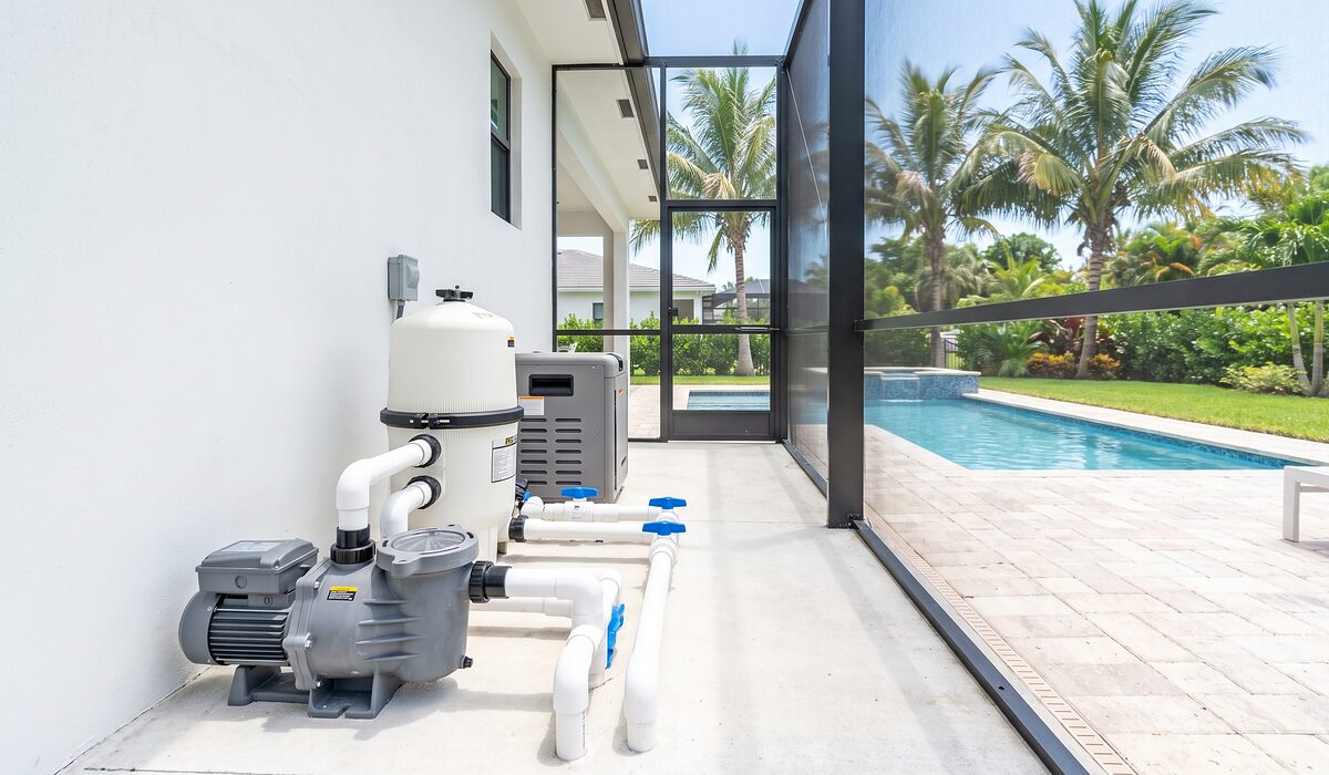 Pool equipment pad with pump, filter, and plumbing beside a Florida home