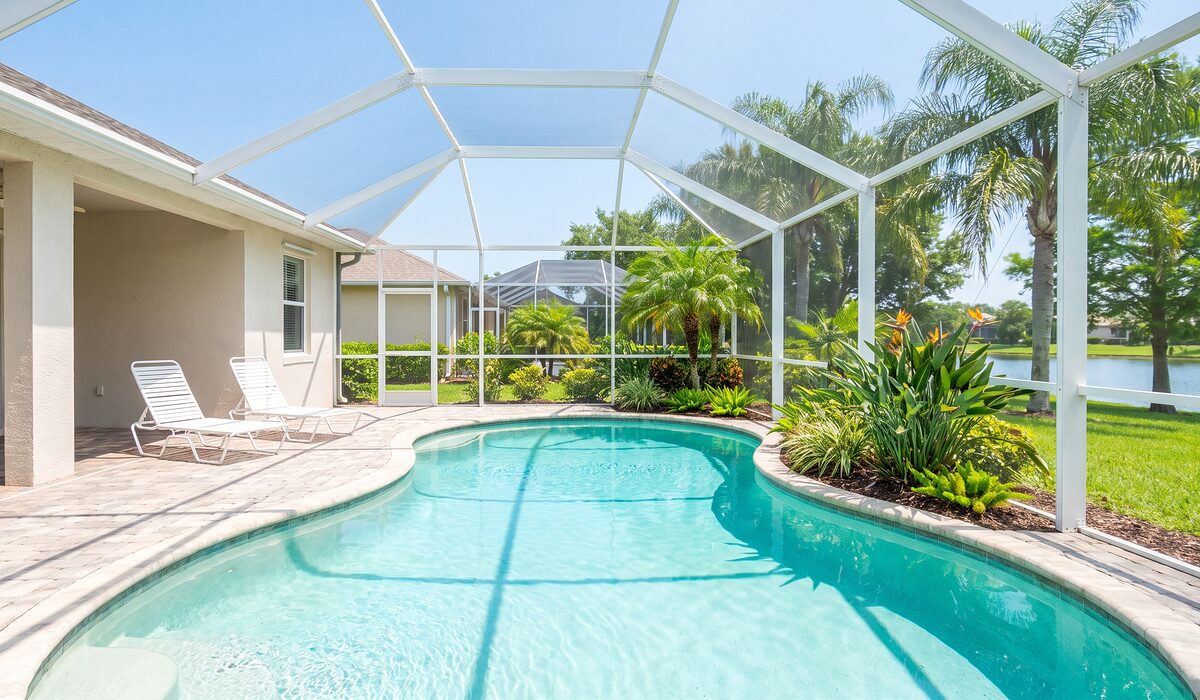 Sparkling backyard swimming pool inside a screened lanai at a Florida home