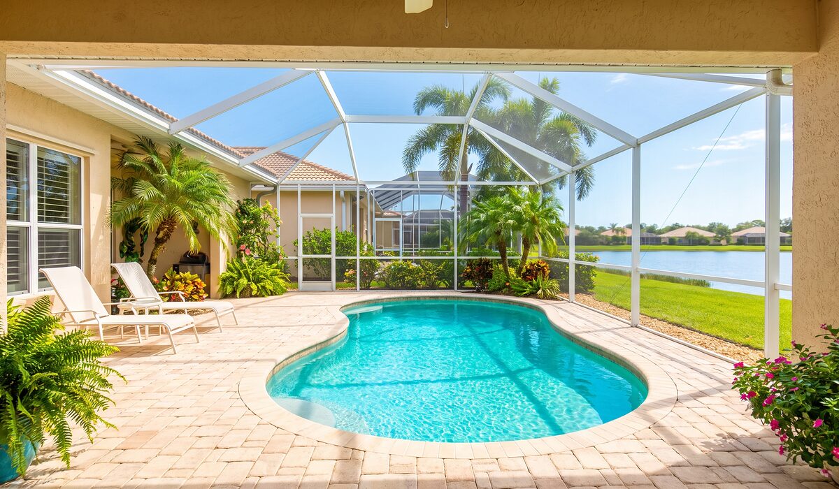 Sparkling backyard swimming pool inside a screened lanai at a Florida home