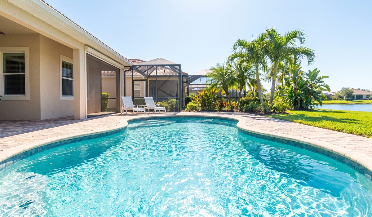 Sparkling backyard swimming pool inside a screened lanai at a Florida home