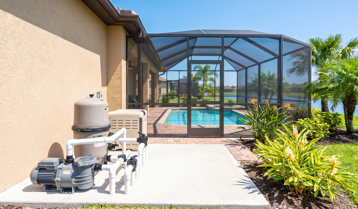 Pool equipment pad with pump, filter, and plumbing beside a Florida home