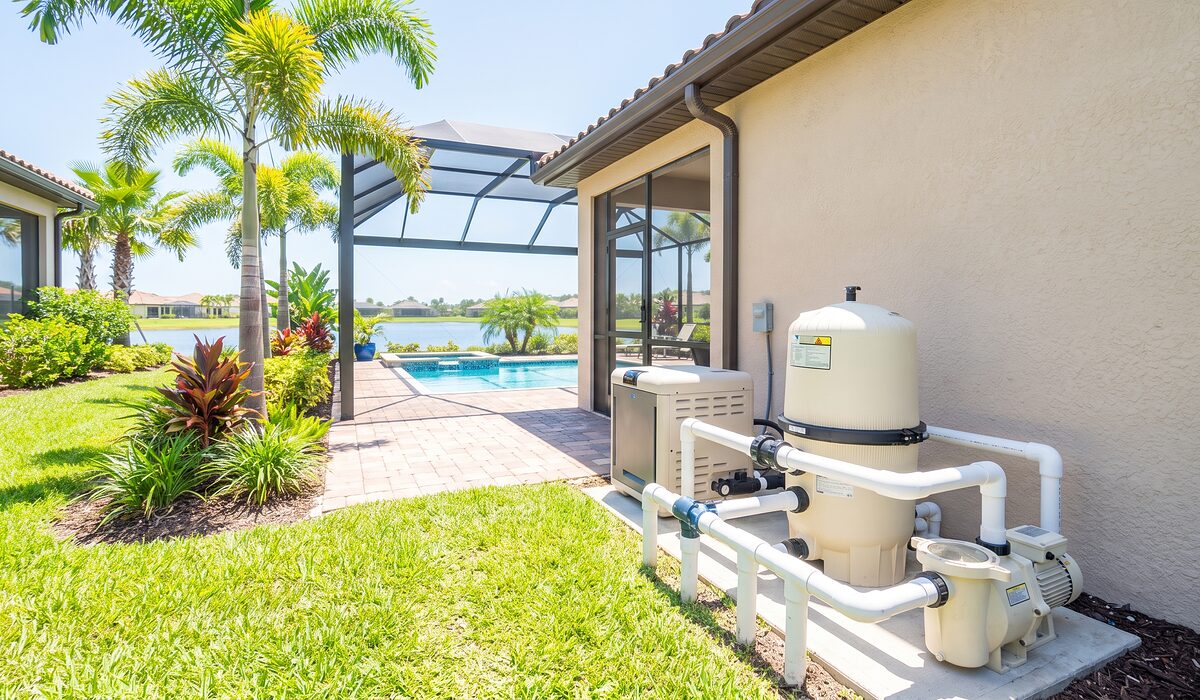 Pool equipment pad with pump, filter, and plumbing beside a Florida home