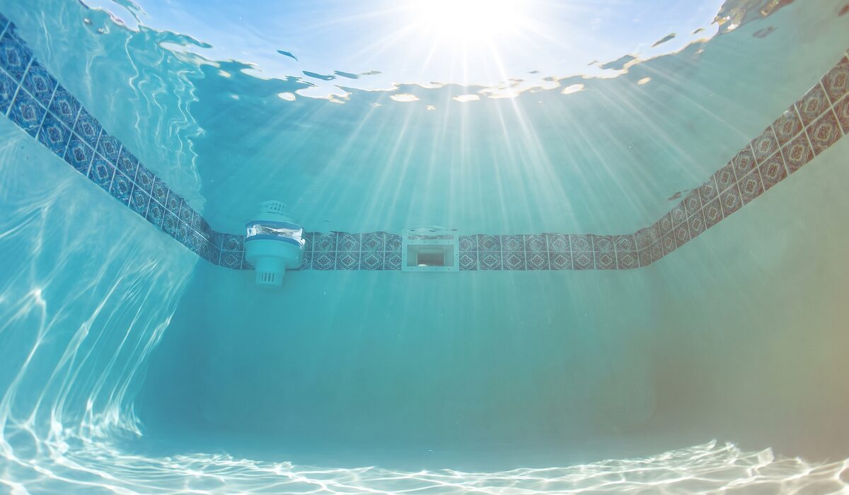 Underwater view of a clear swimming pool with sunlight through the water