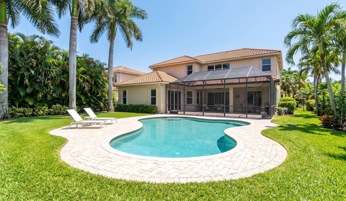 Sparkling backyard swimming pool inside a screened lanai at a Florida home