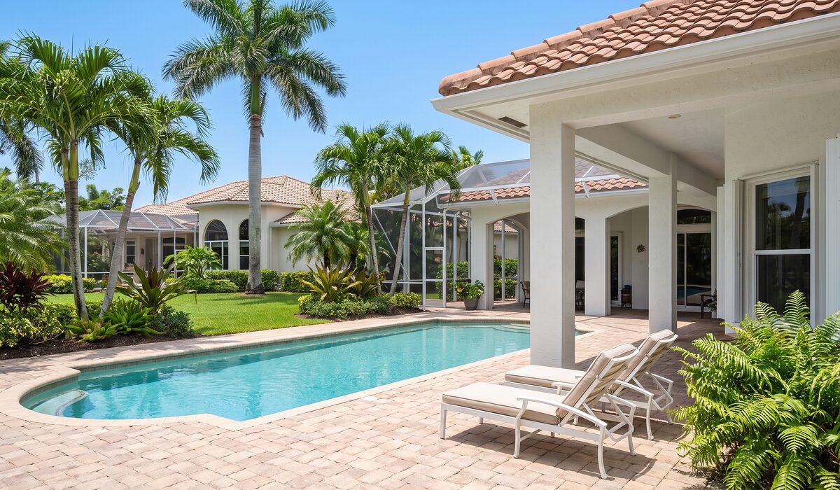 Sparkling backyard swimming pool inside a screened lanai at a Florida home