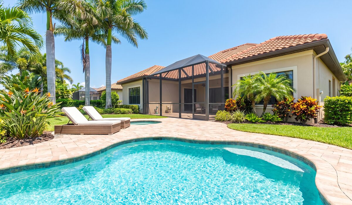 Sparkling backyard swimming pool inside a screened lanai at a Florida home