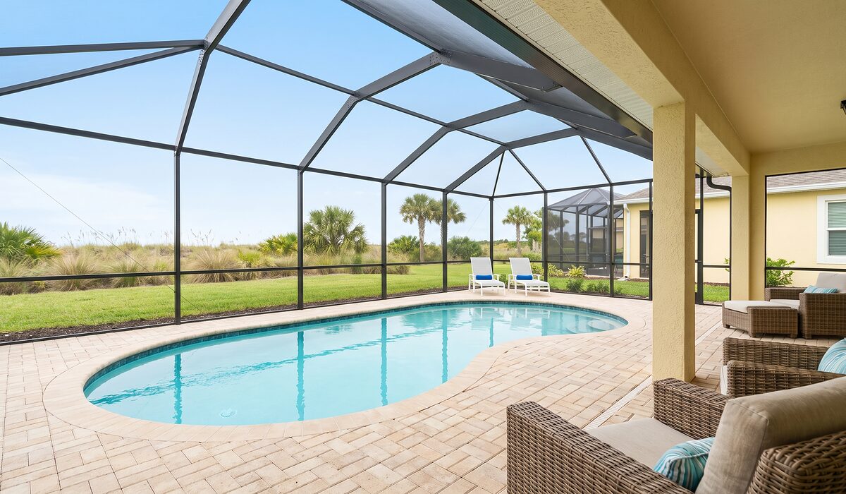 Sparkling backyard swimming pool inside a screened lanai at a Florida home