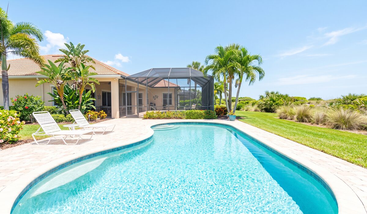 Sparkling backyard swimming pool inside a screened lanai at a Florida home