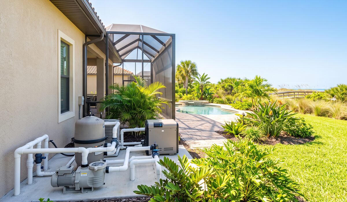 Pool equipment pad with pump, filter, and plumbing beside a Florida home