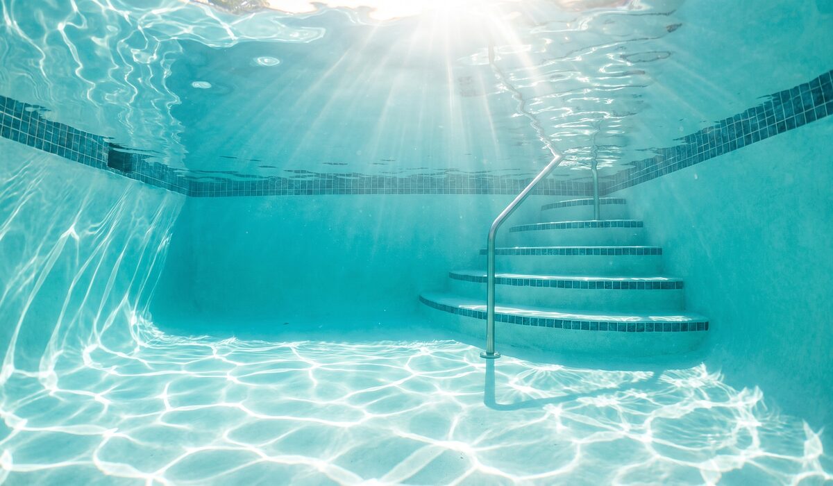 Underwater view of a clear swimming pool with sunlight through the water