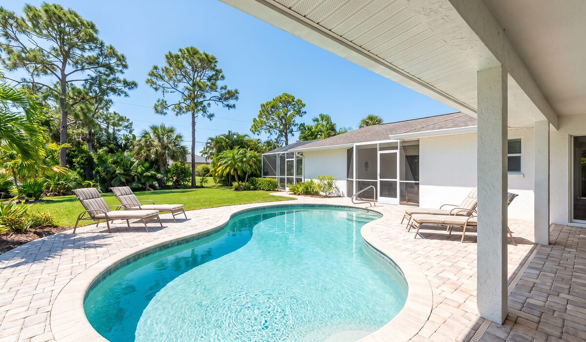 Sparkling backyard swimming pool inside a screened lanai at a Florida home