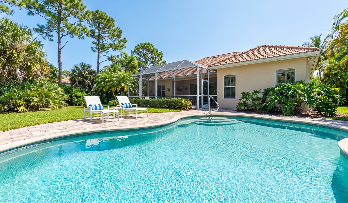 Sparkling backyard swimming pool inside a screened lanai at a Florida home