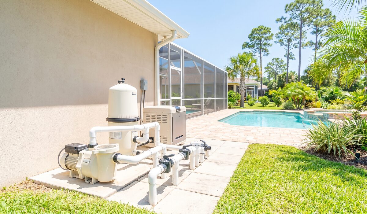 Pool equipment pad with pump, filter, and plumbing beside a Florida home