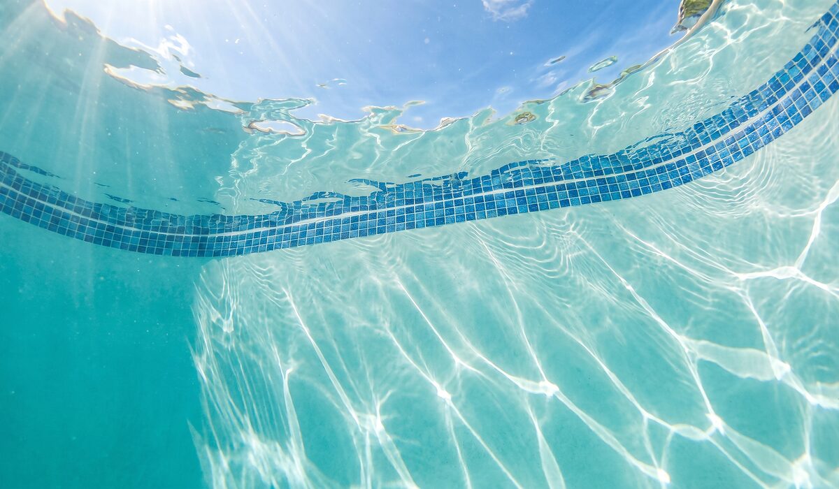 Underwater view of a clear swimming pool with sunlight through the water