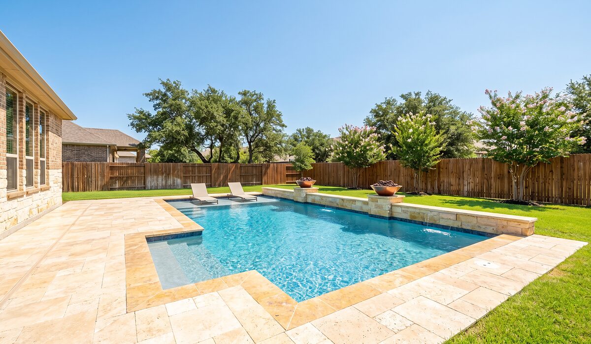 Newly built custom gunite pool with a travertine deck at a Texas home