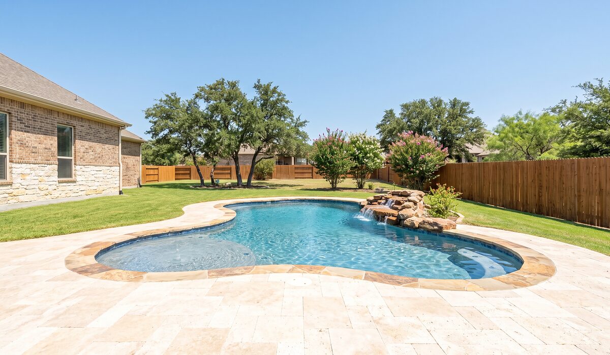 Newly built custom gunite pool with a travertine deck at a Texas home