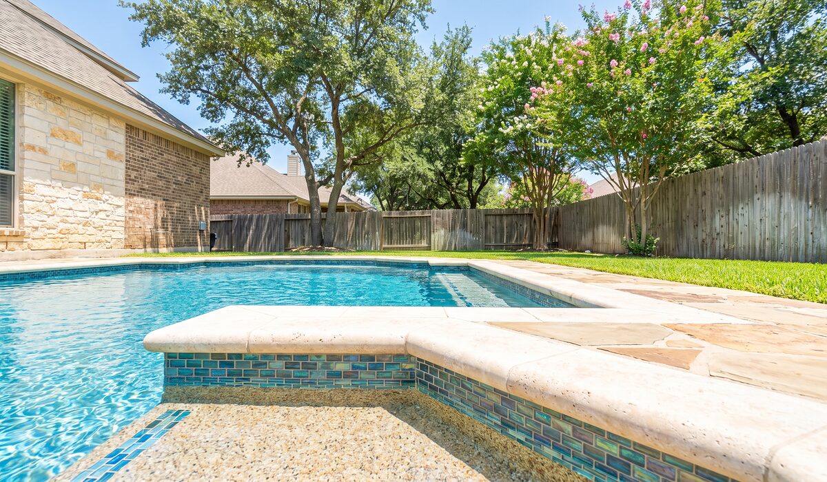 Remodeled swimming pool with new tile and coping on a sunny day