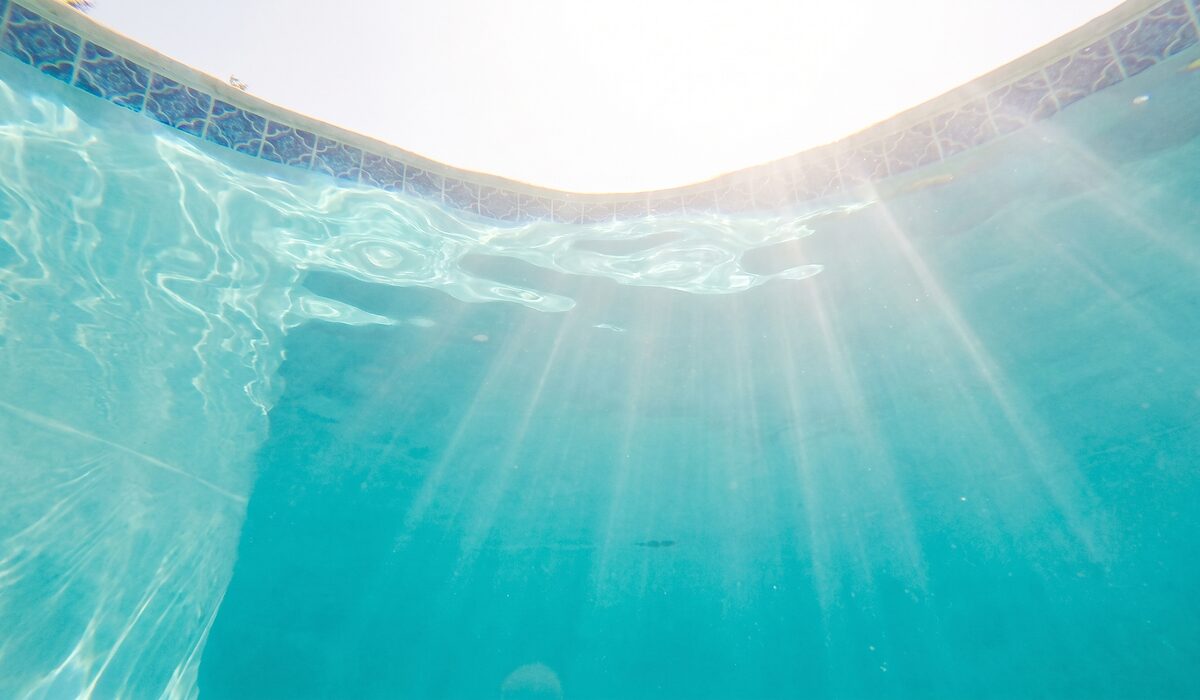 Underwater view of a clear swimming pool with sunlight through the water