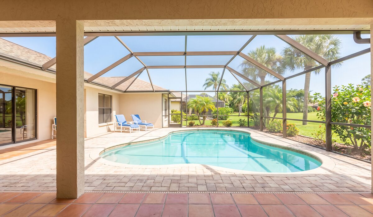 Sparkling backyard swimming pool inside a screened lanai at a Florida home