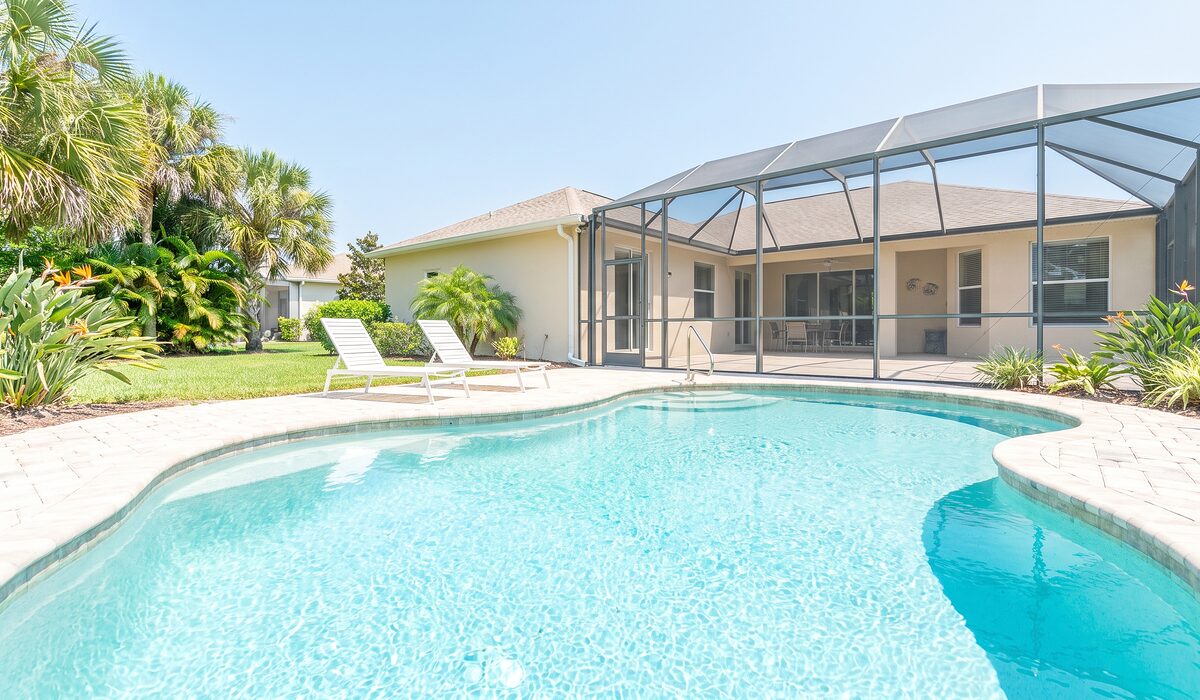 Sparkling backyard swimming pool inside a screened lanai at a Florida home