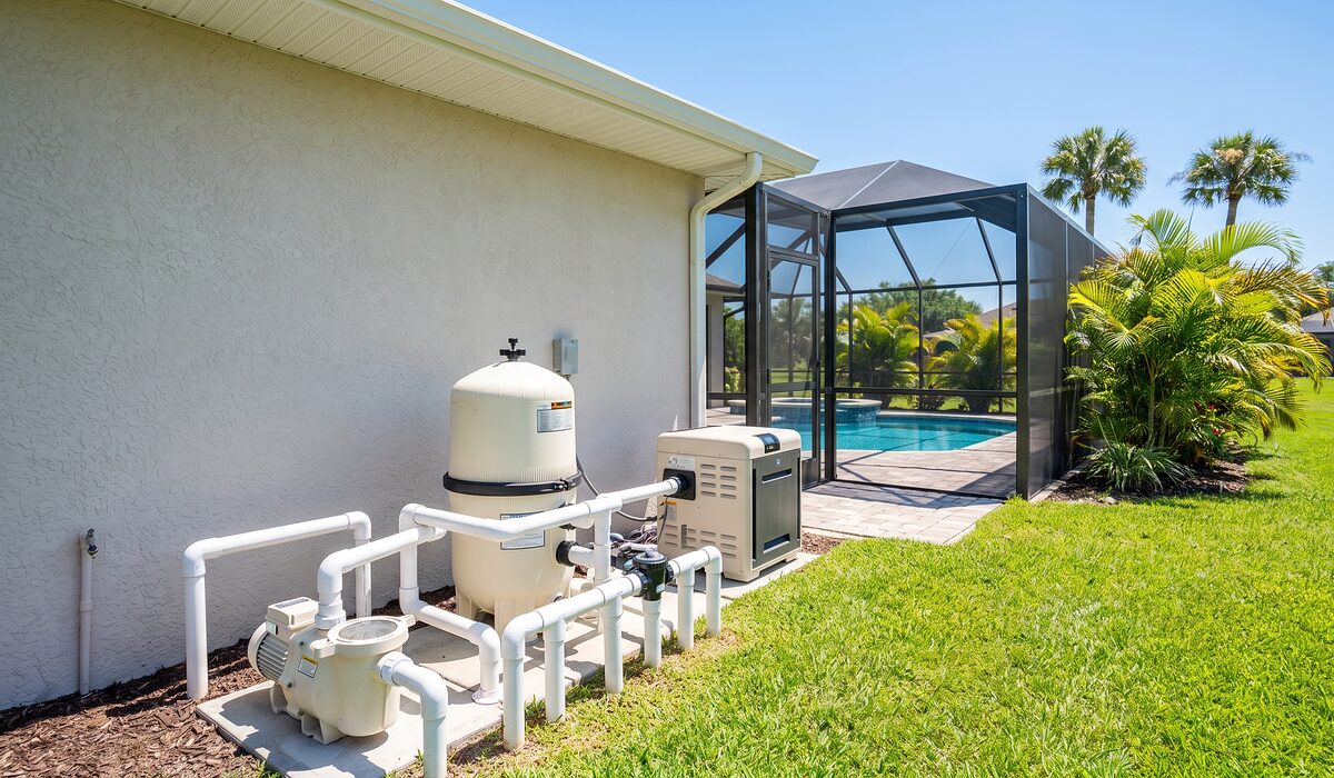 Pool equipment pad with pump, filter, and plumbing beside a Florida home